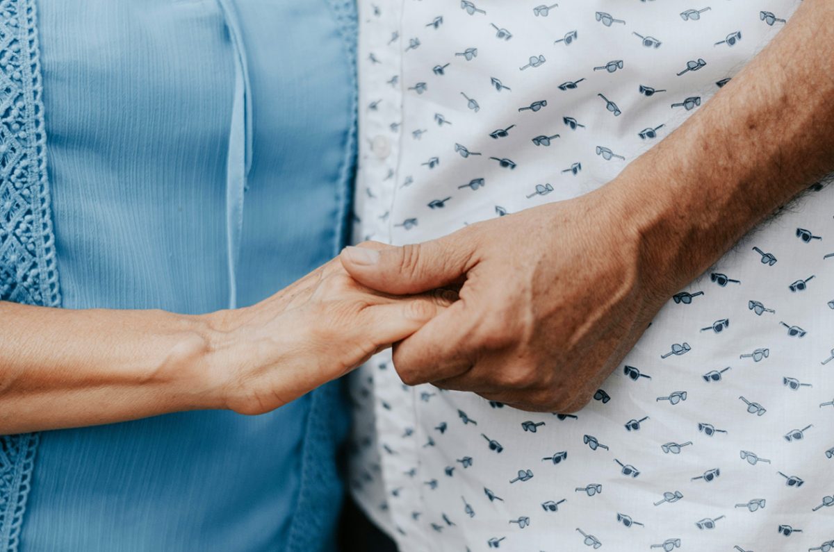 Two people holding hands in a gesture of support